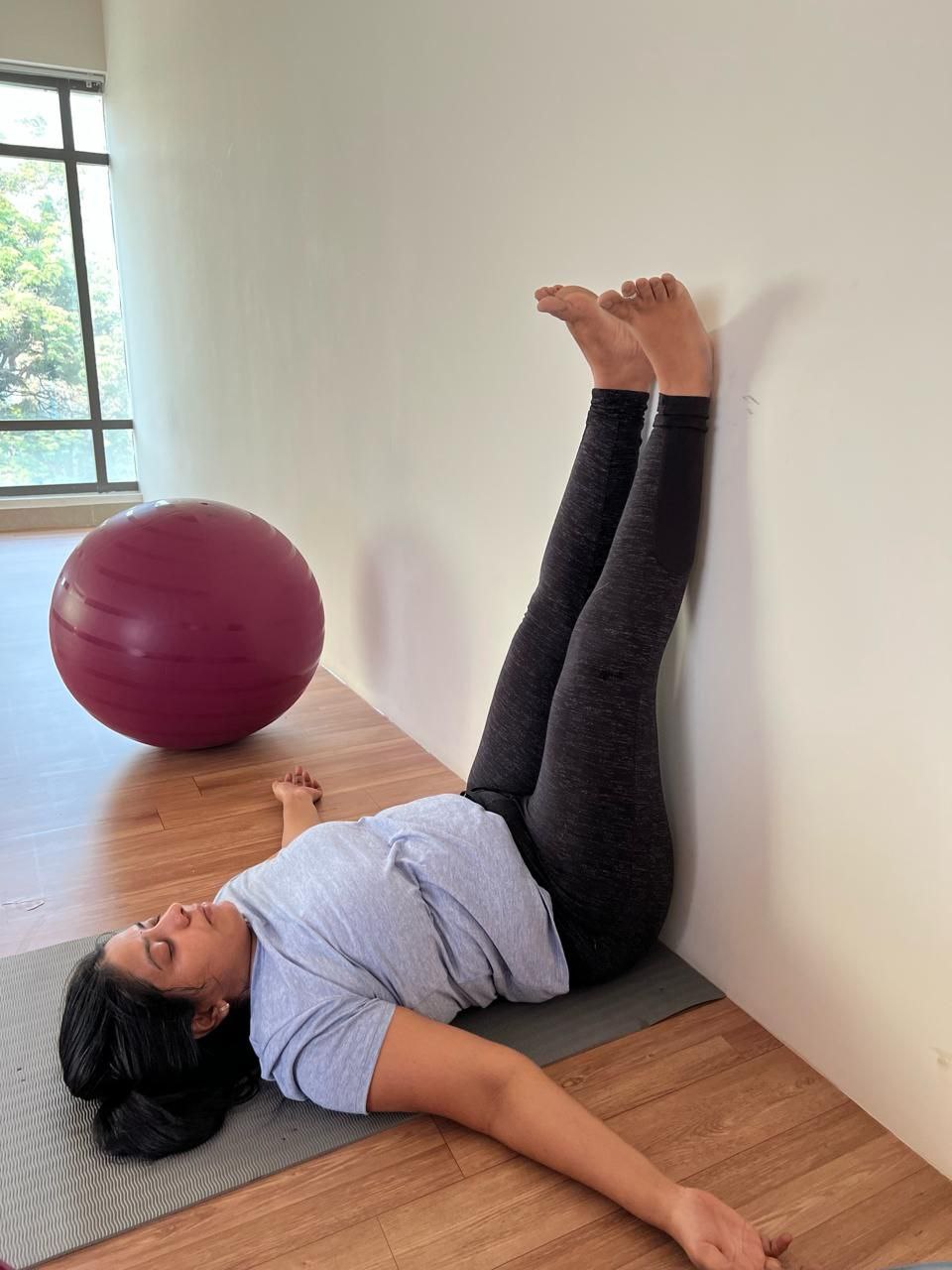 Postnatal yoga session at Aura, featuring women in a variety of poses for holistic well-being.